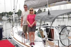 happy couple standing on sailboat