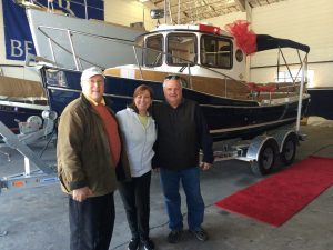 happy owners standing in front of new Ranger tug